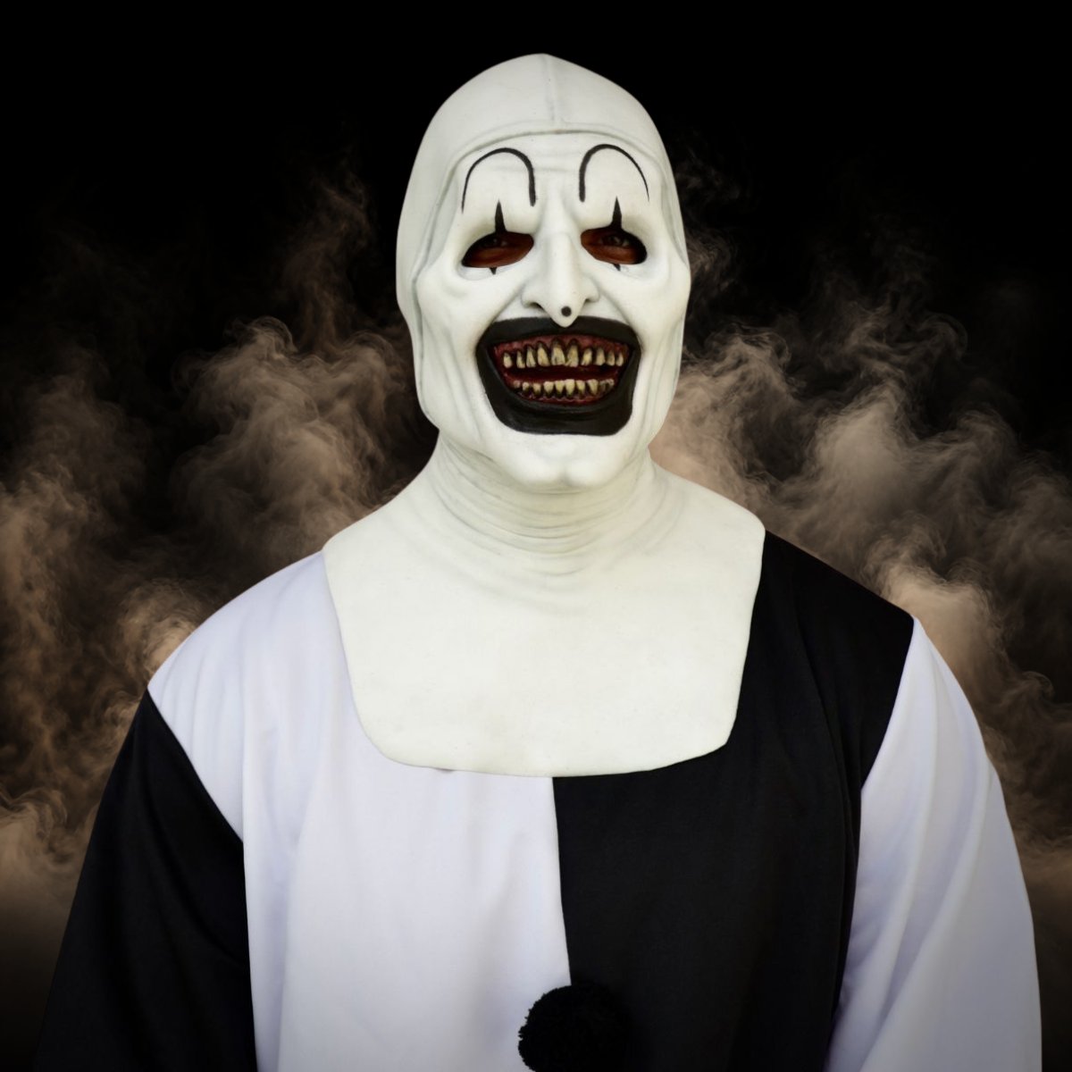 Black and white clown mask with a wide toothy grin worn with a ruffled costume