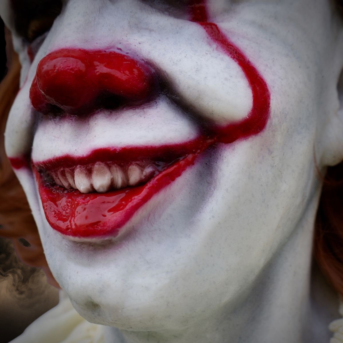 Close up of the red lips and teeth on a realistic clown mask